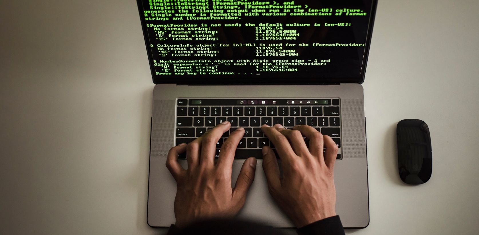 A man hands typing on a laptop